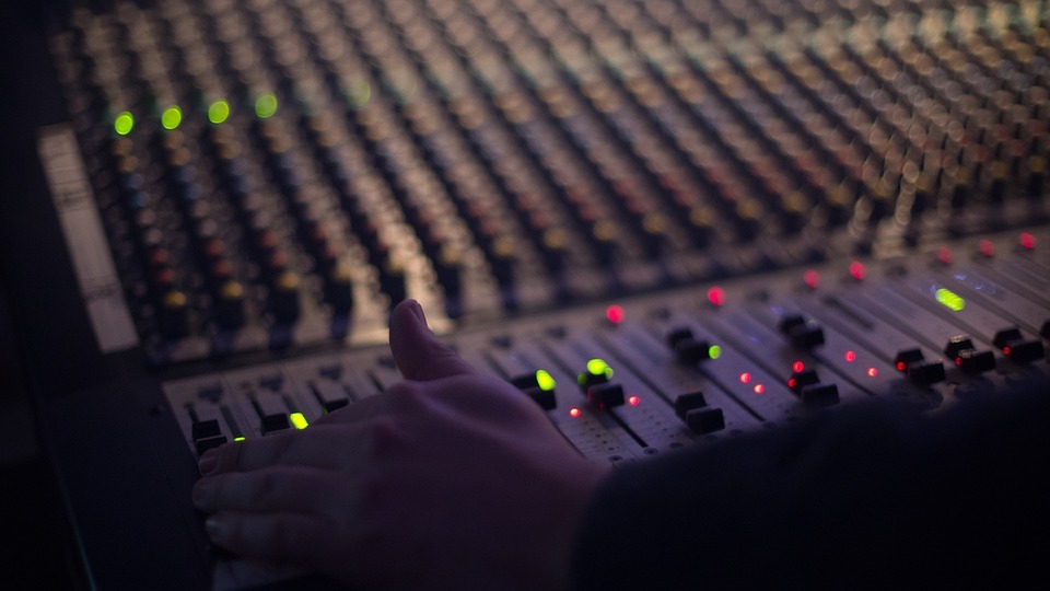 audio engineer with hand on mixer 