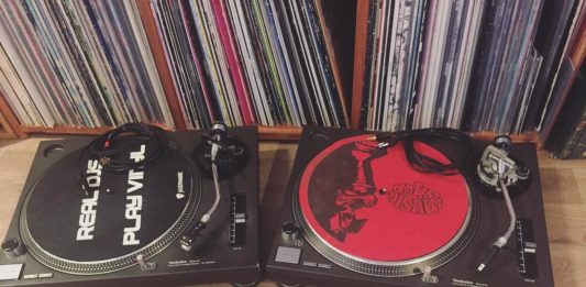 two technic 1200 turntables with records on shelf