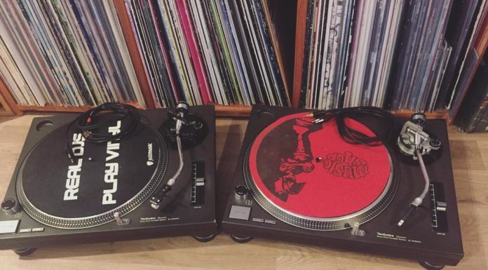 two technic 1200 turntables with records on shelf