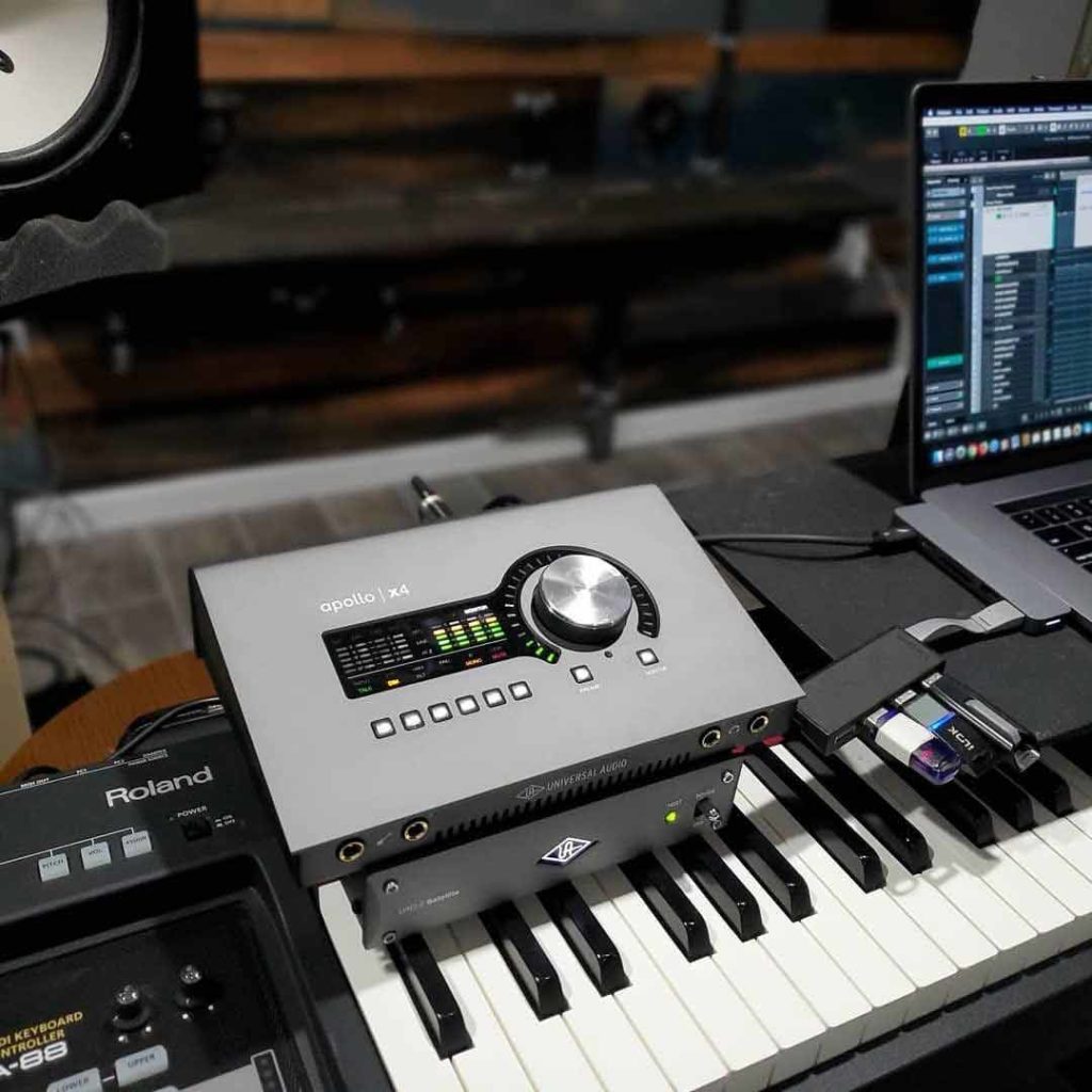 audio interface on keyboard with laptop and studio monitors