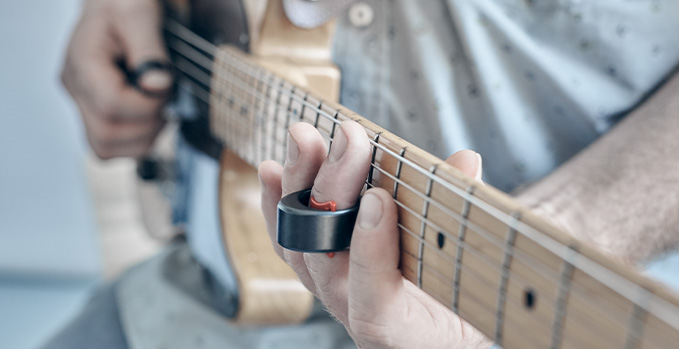 guitar player playing electric guitar with steel guitar slide ring