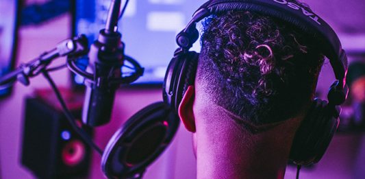 Image of a vocal artist in a studio recording vocals