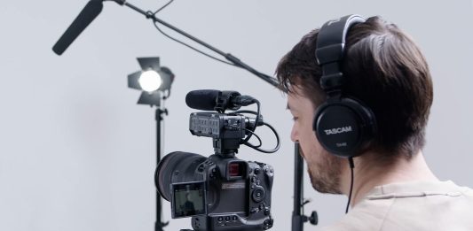 man using TASCAM CA-XLR2D DSLR camera microphone and sound recorder