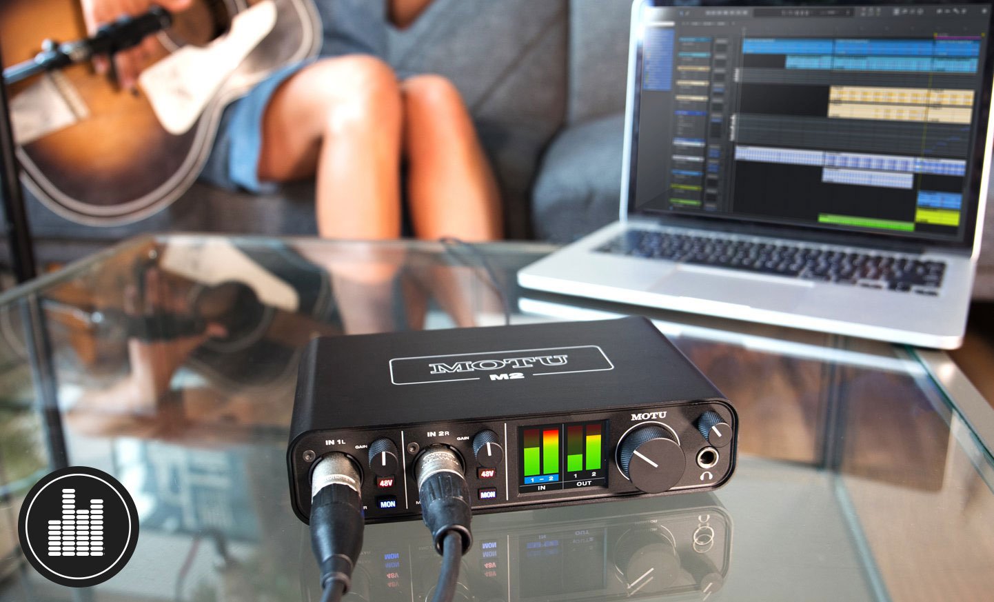 Image of MOTU M2 audio interface connected to laptop and recording a woman playing guitar