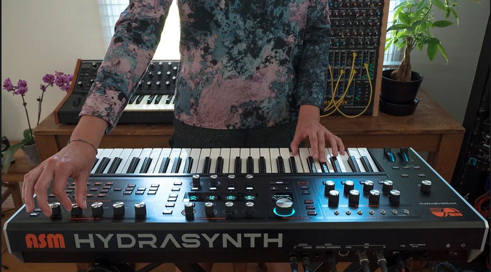 image of a person playing the ASM Hydrasynth Explorer synthesizer