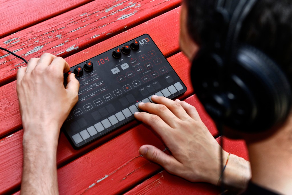 image of the IK Multimedia UNO Synth in use by a man wearing headphones